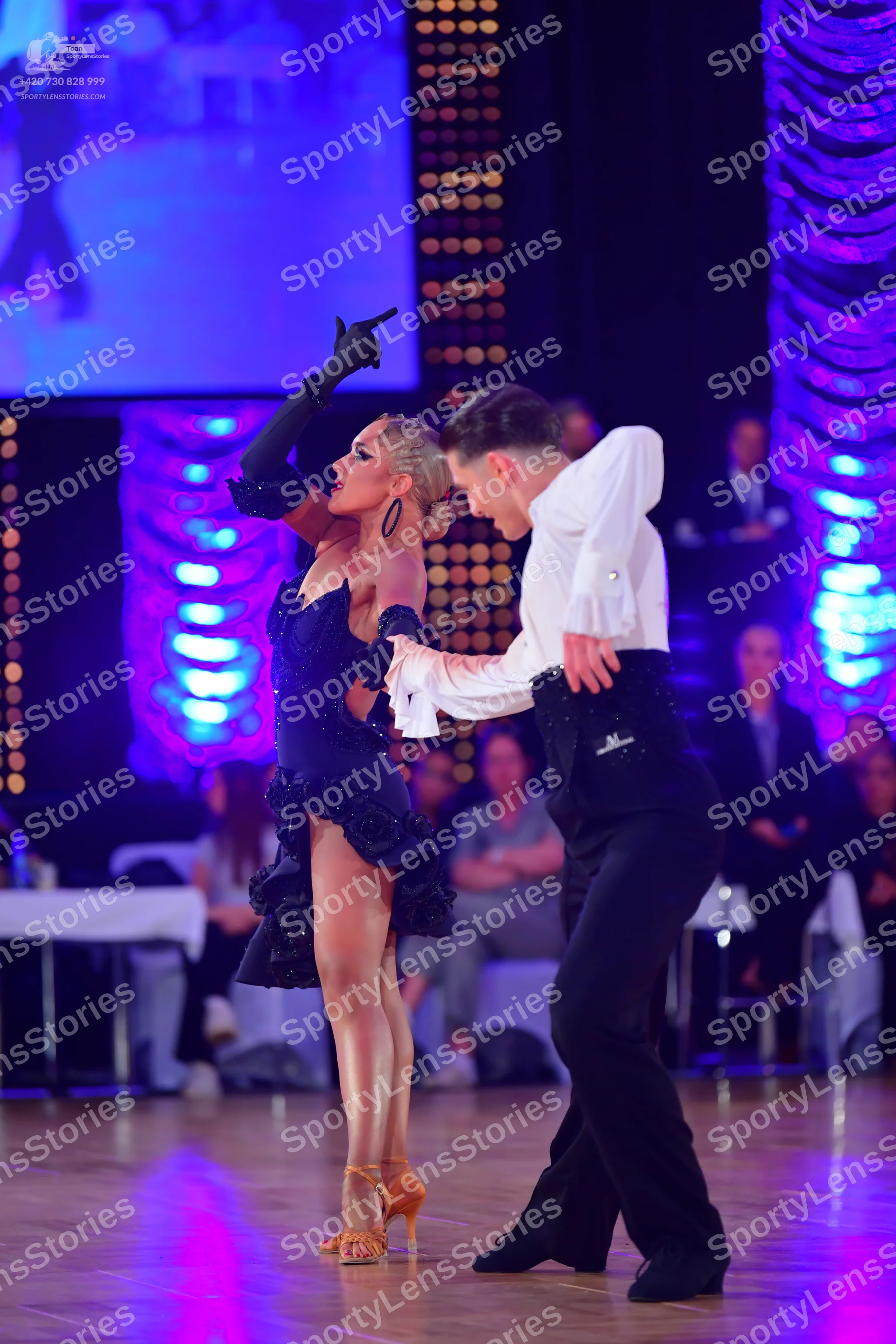 Dancesport competitor: Female dancer: black latin dress with long black gloves and large earrings
