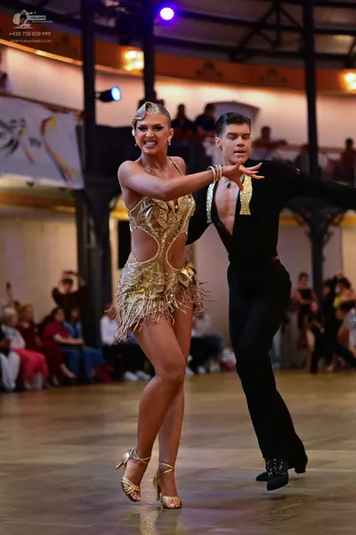Dancesport competitor: Female dancer: gold sequined latin dress with fringe and gold strappy heels