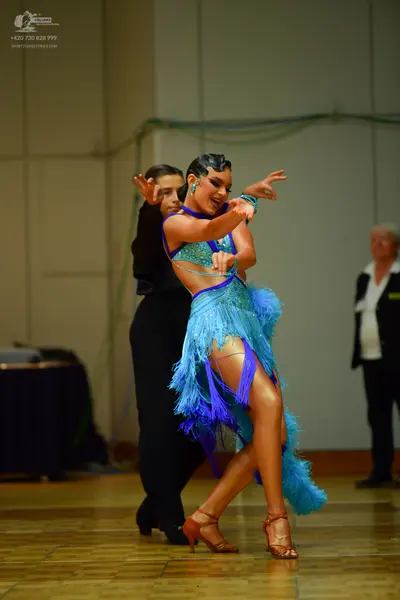 Dancesport competitor: Female dancer: light blue and dark blue latin dress with fringe and sequins on t