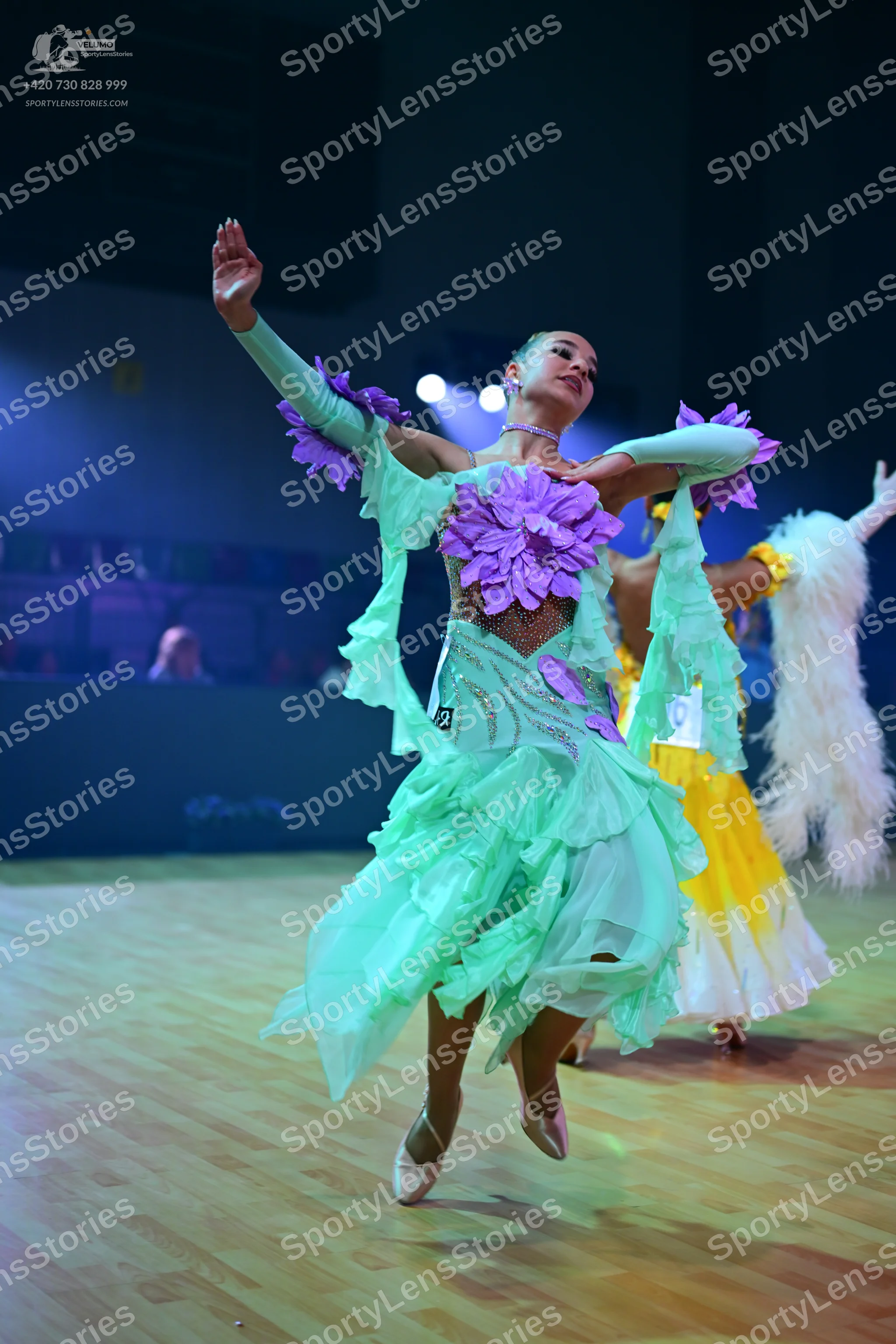 Dancesport competitor: Female dancer 1: mint green latin dress with large purple fabric flowers on the