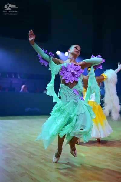 Dancesport competitor: Female dancer 1: mint green latin dress with large purple fabric flowers on the 