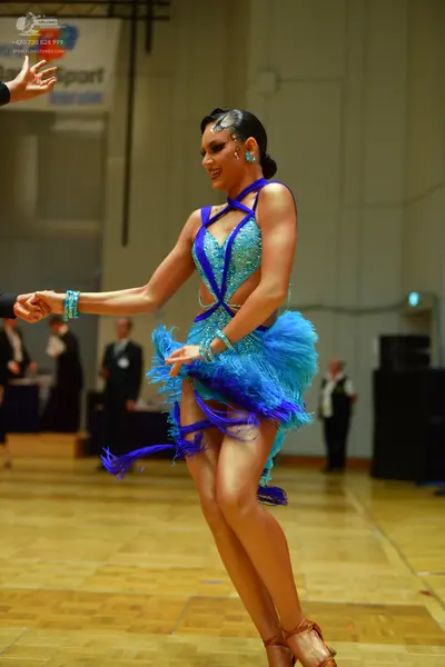 Dancesport competitor: Female dancer: turquoise blue latin dance dress with sequins, fringe, and cutout