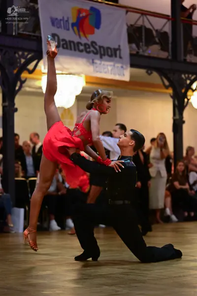 Dancesport competitor: Female dancer: red latin dress with thin straps and sparkling embellishments on 