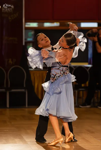 Dancesport competitor: Male dancer: black trousers, white shirt, and black waistcoat or tie