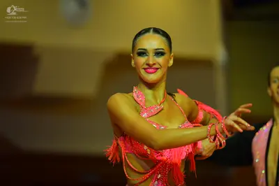 Dancesport competitor: Female dancer: bright pink Latin dress with sequins and fringe