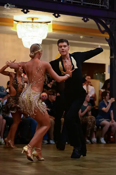 Dancesport competitor: Male dancer: black suit with large gold sequined lapels