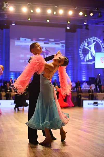 Dancesport competitor: Female dancer: light blue Latin dance dress with a flowing skirt and large, volu