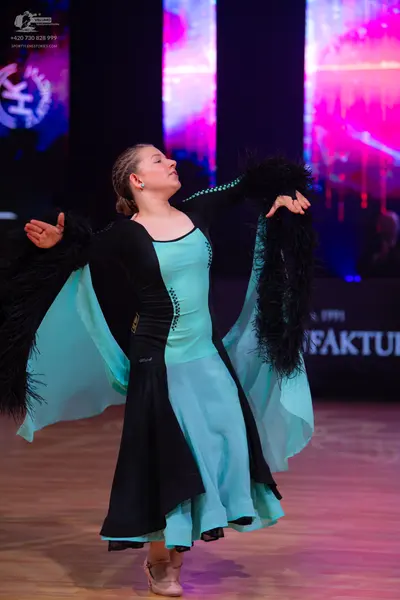 Dancesport competitor: Female dancer: light blue and black ballroom dress featuring large black feather