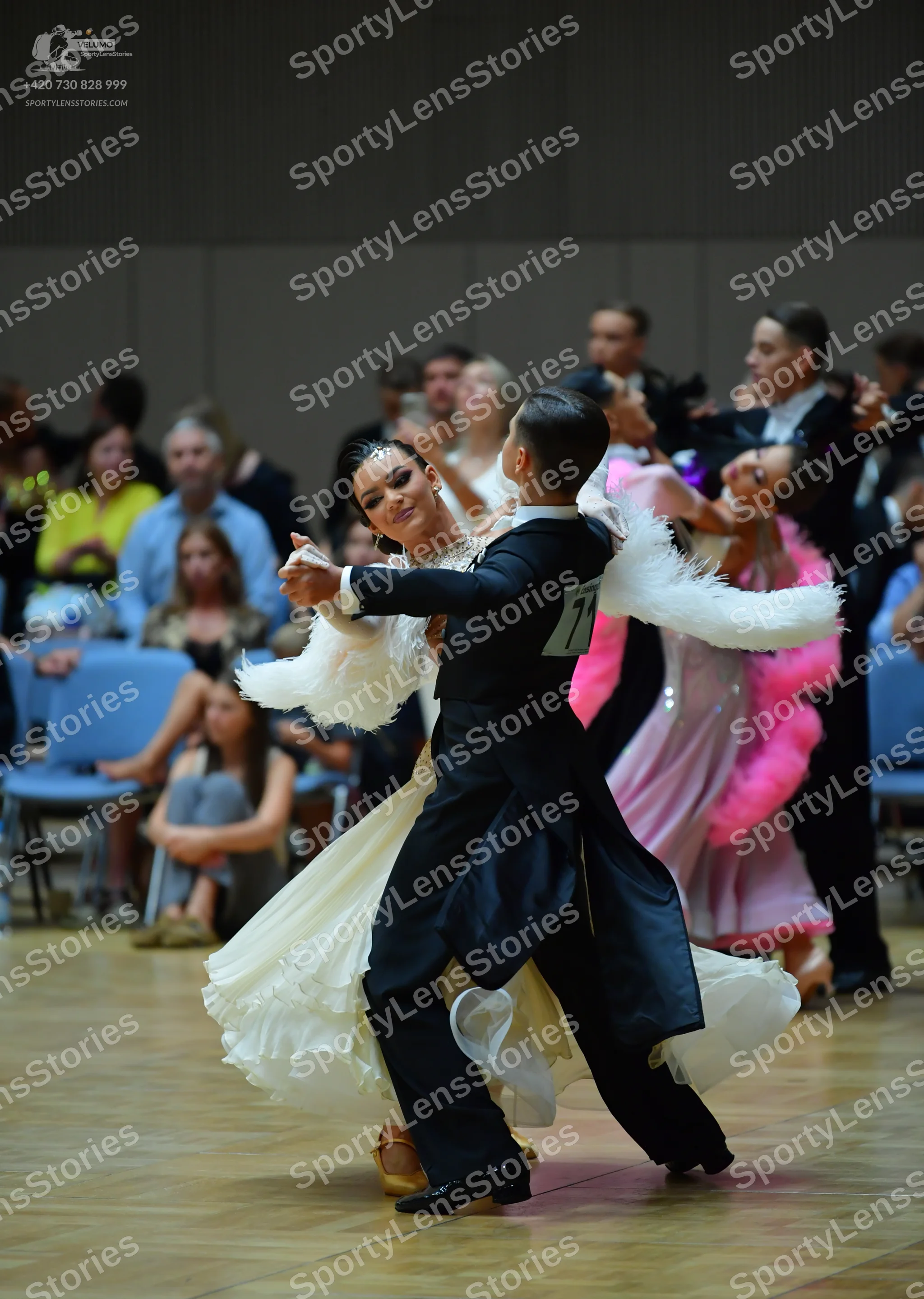 Dancesport competitor: Male dancer: black suit with white feathery trim on the sleeves and a white shir