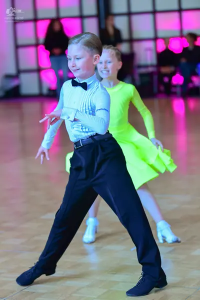Dancesport competitor: Male dancer: light blue long-sleeved pleated shirt with a black bow tie and blac