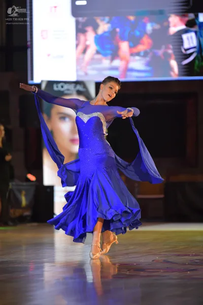 Dancesport competitor #16: Female dancer: royal blue ballroom dress with long sleeves, silver sequin embell