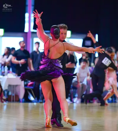 Dancesport competitor #181: Female dancer: dark purple sequin latin dress with a low back and short flared s