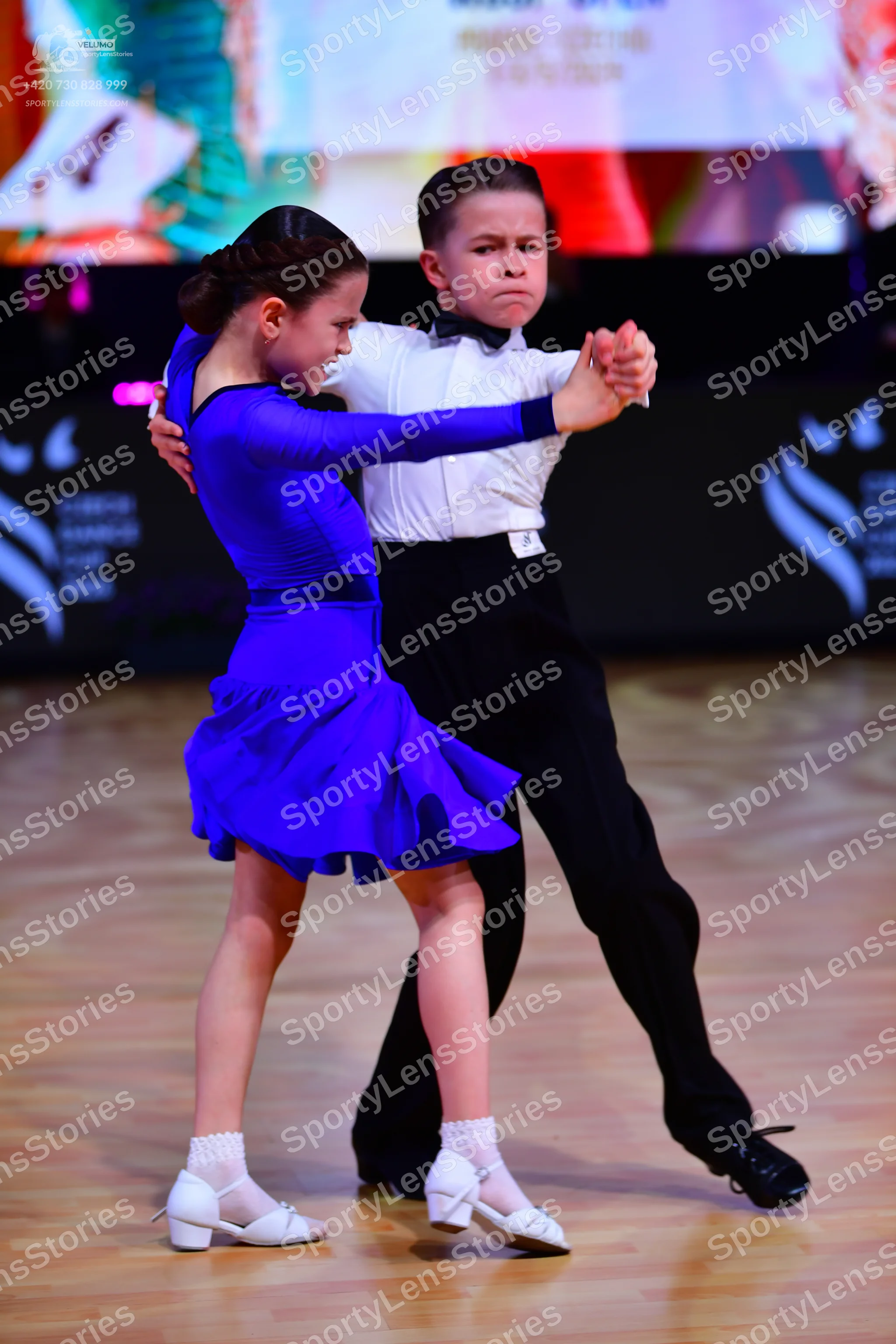 Dancesport competitor: Male dancer: white long-sleeved shirt with a black bowtie, black trousers, and b