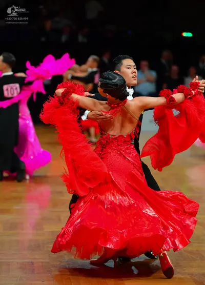 Dancesport competitor: Dancer on the left: black suit with a bright pink ruffled dress