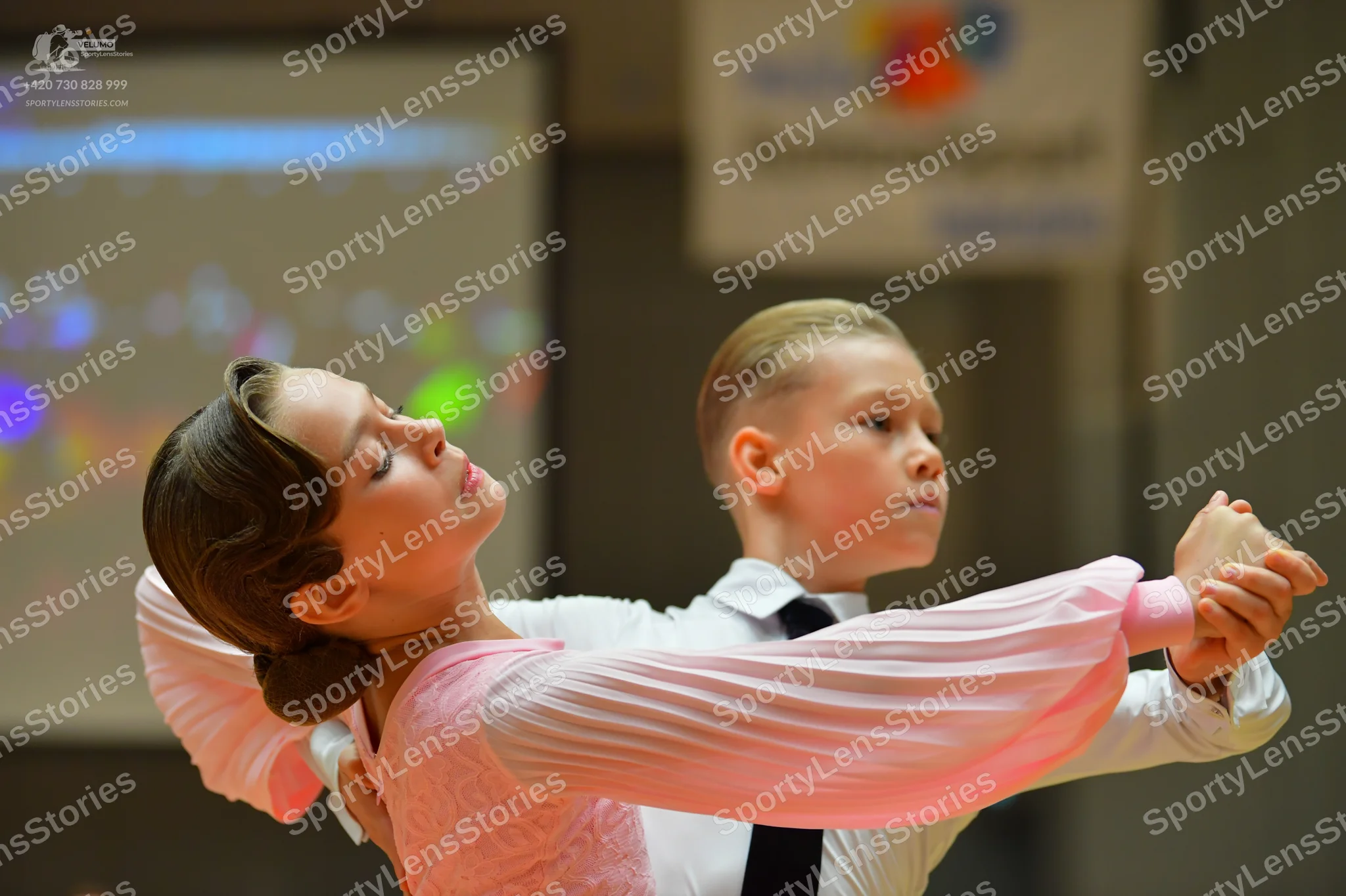 Dancesport competitor: Female dancer: light pink long-sleeved dance dress with a textured or lace bodic