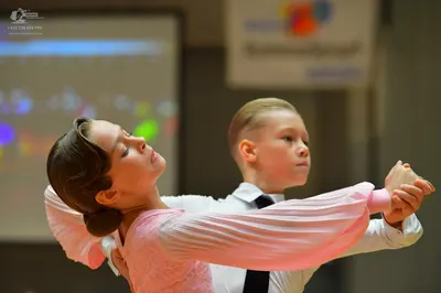 Dancesport competitor: Female dancer: light pink long-sleeved dance dress with a textured or lace bodic