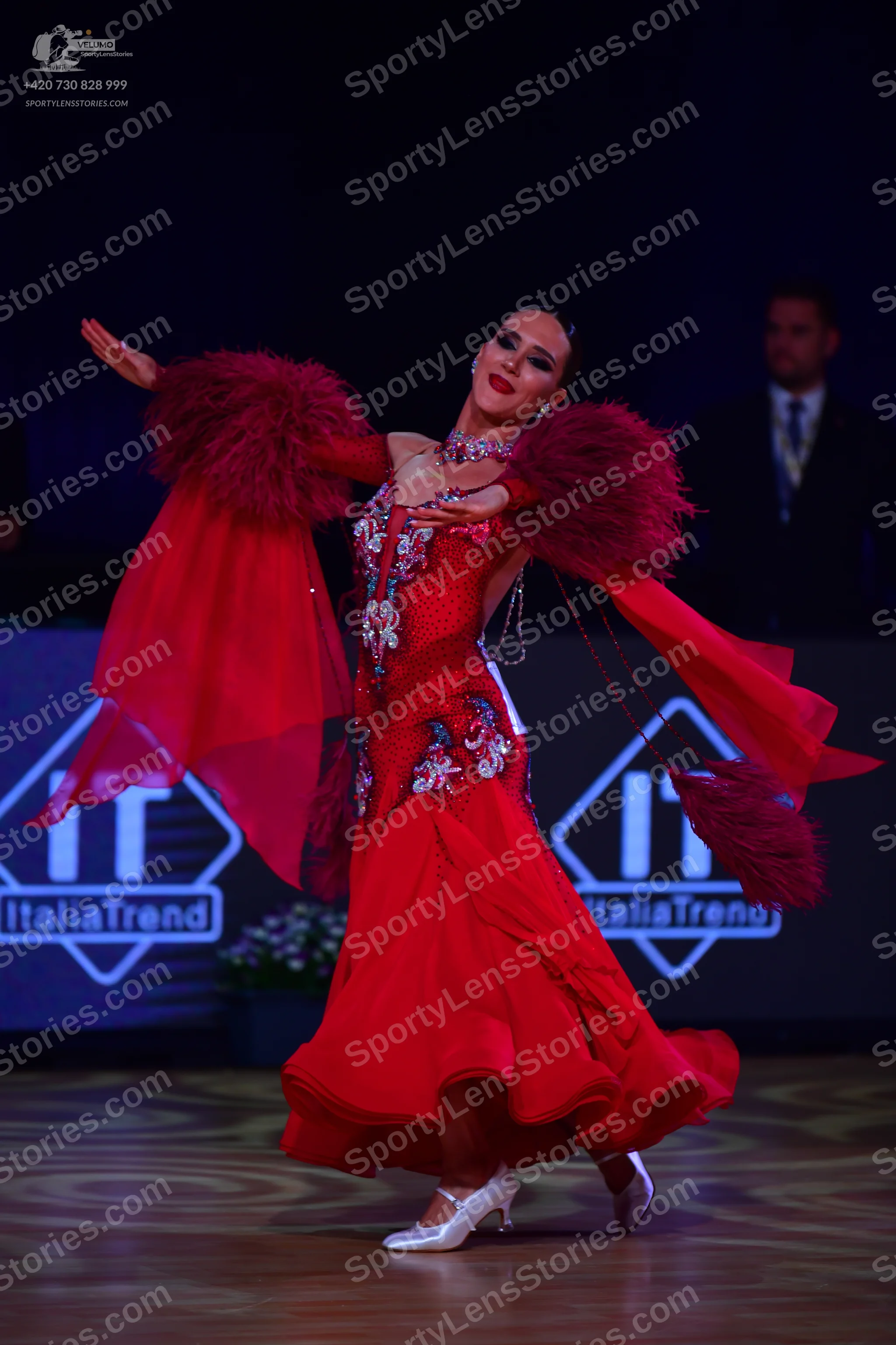 Dancesport competitor: Female dancer: red ballroom dress with a silver sequined bodice, long sheer red 