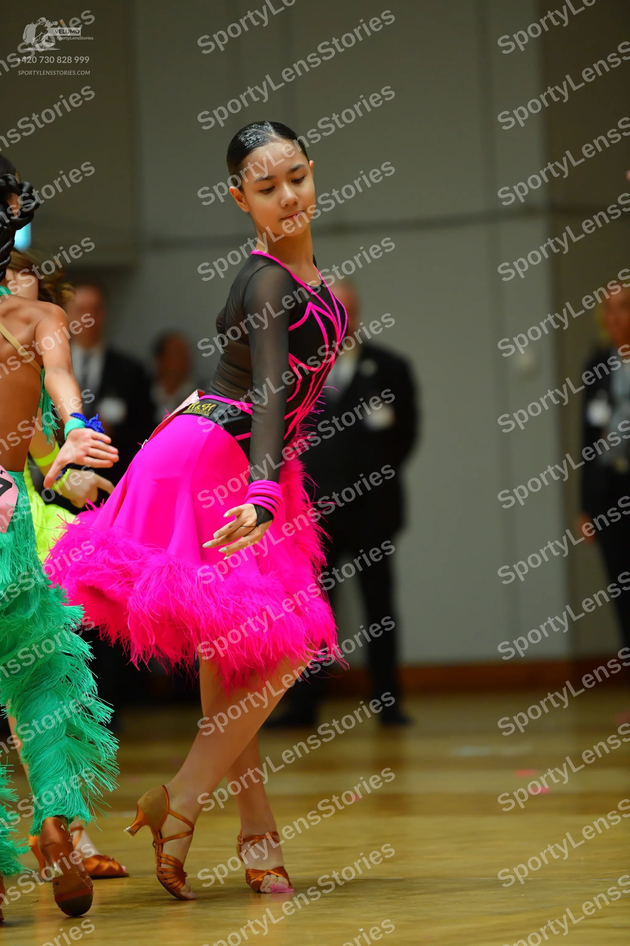 Dancesport competitor: Female dancer: black latin dress top with pink piping and long sleeves, with a b
