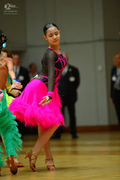 Dancesport competitor: Female dancer: black latin dress top with pink piping and long sleeves, with a b