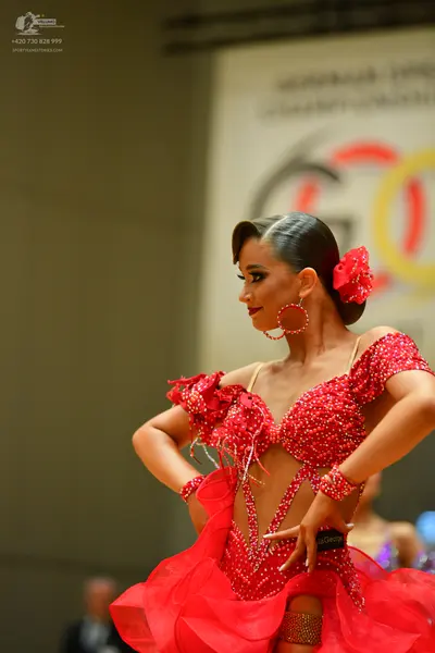 Dancesport competitor: Female dancer: red Latin dress with red sequins and beads, featuring cutouts and