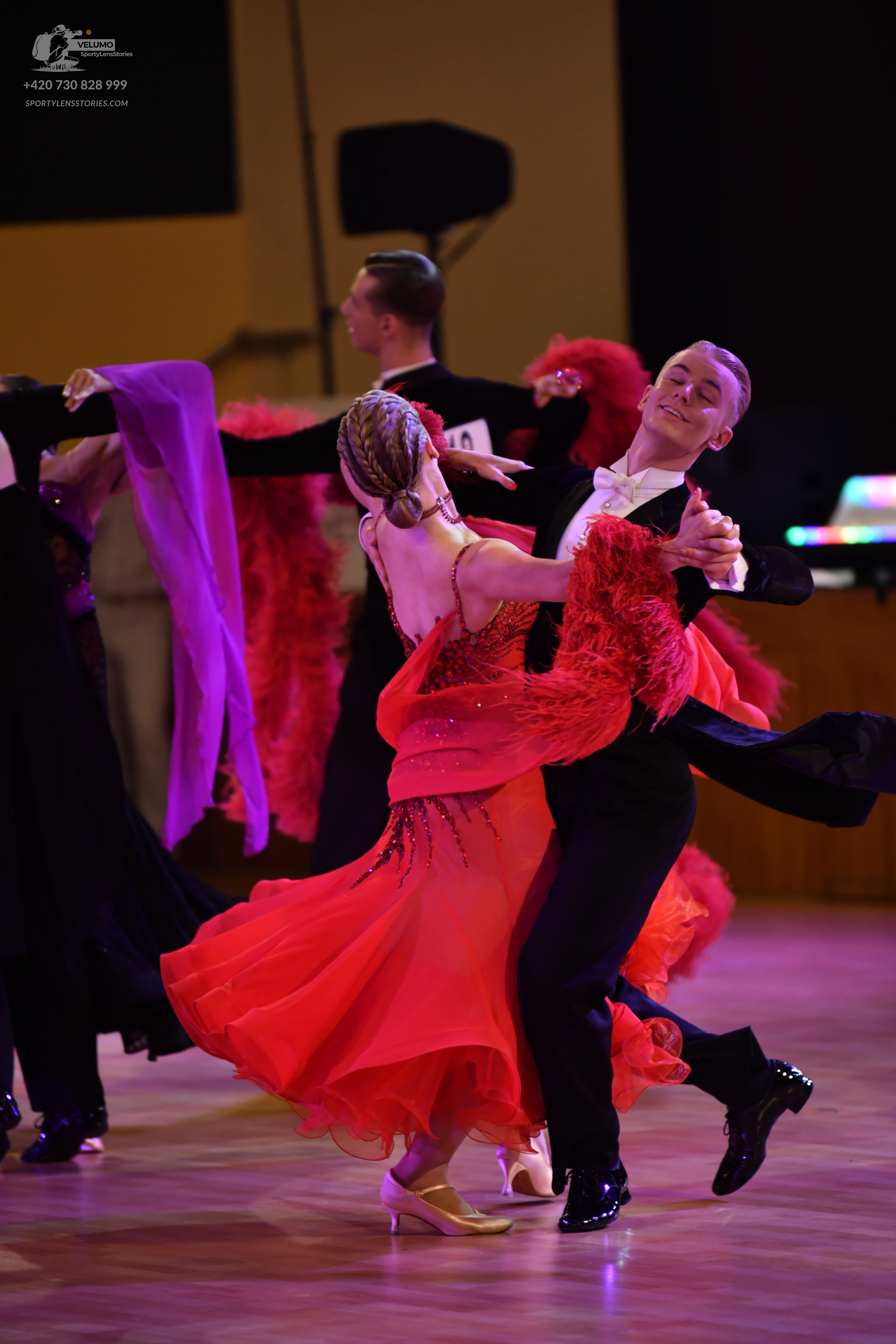 Dancesport competitor: Female dancer: red Latin dance dress with red feathery or fringe embellishments 