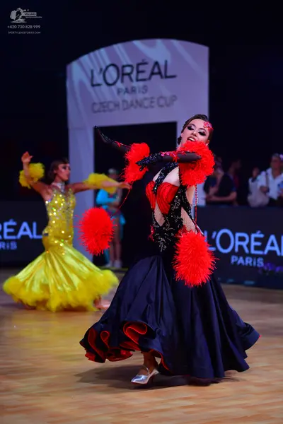 Dancesport competitor: Female dancer 1: yellow sequined latin dress with a voluminous, flowing skirt