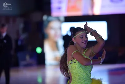 Dancesport competitor: Female dancer: lime green sequined latin dress with sparkly embellishments and g