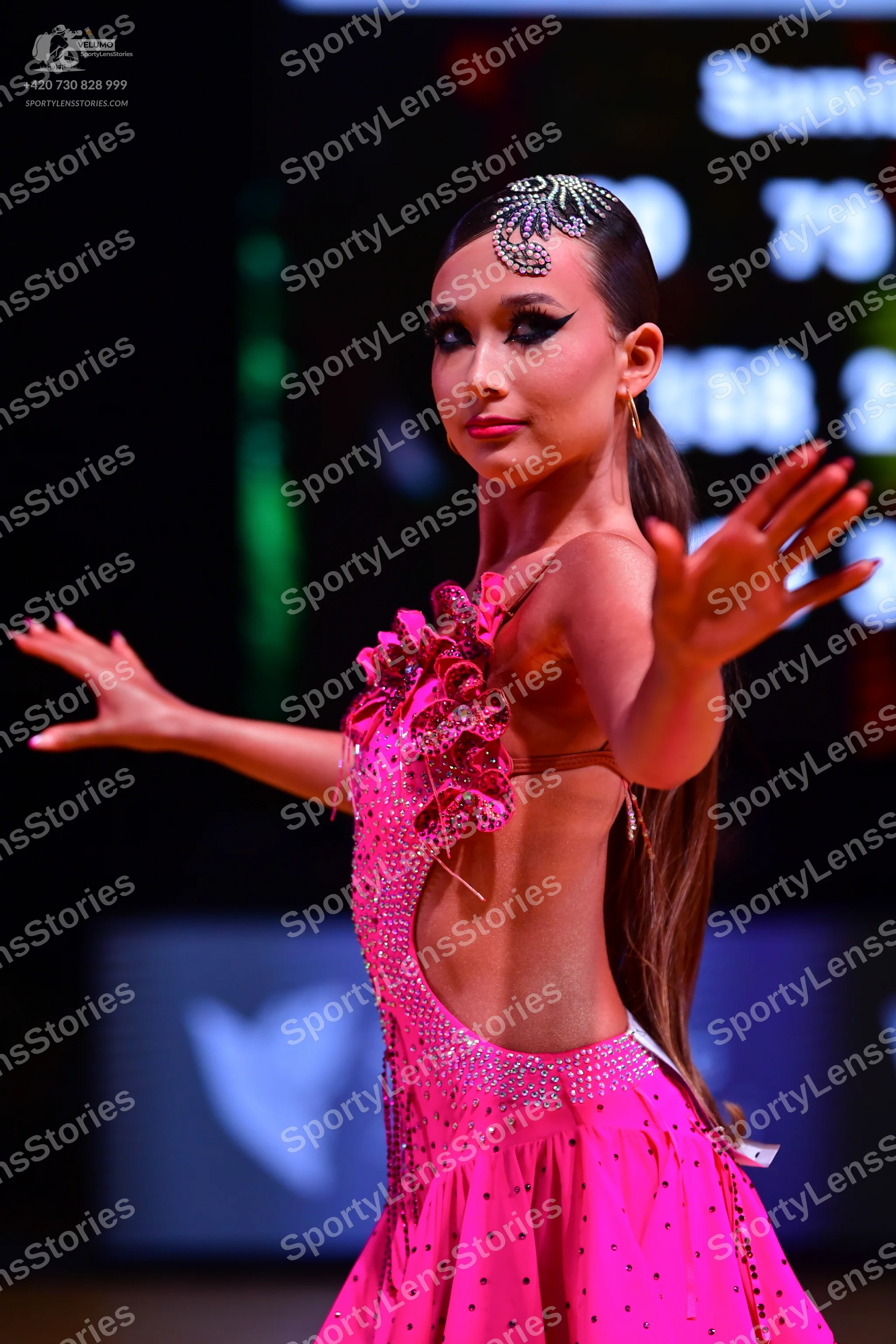 Dancesport competitor: Female dancer: bright pink latin dress with cutout sides, decorated with rhinest