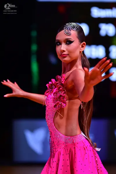 Dancesport competitor: Female dancer: bright pink latin dress with cutout sides, decorated with rhinest