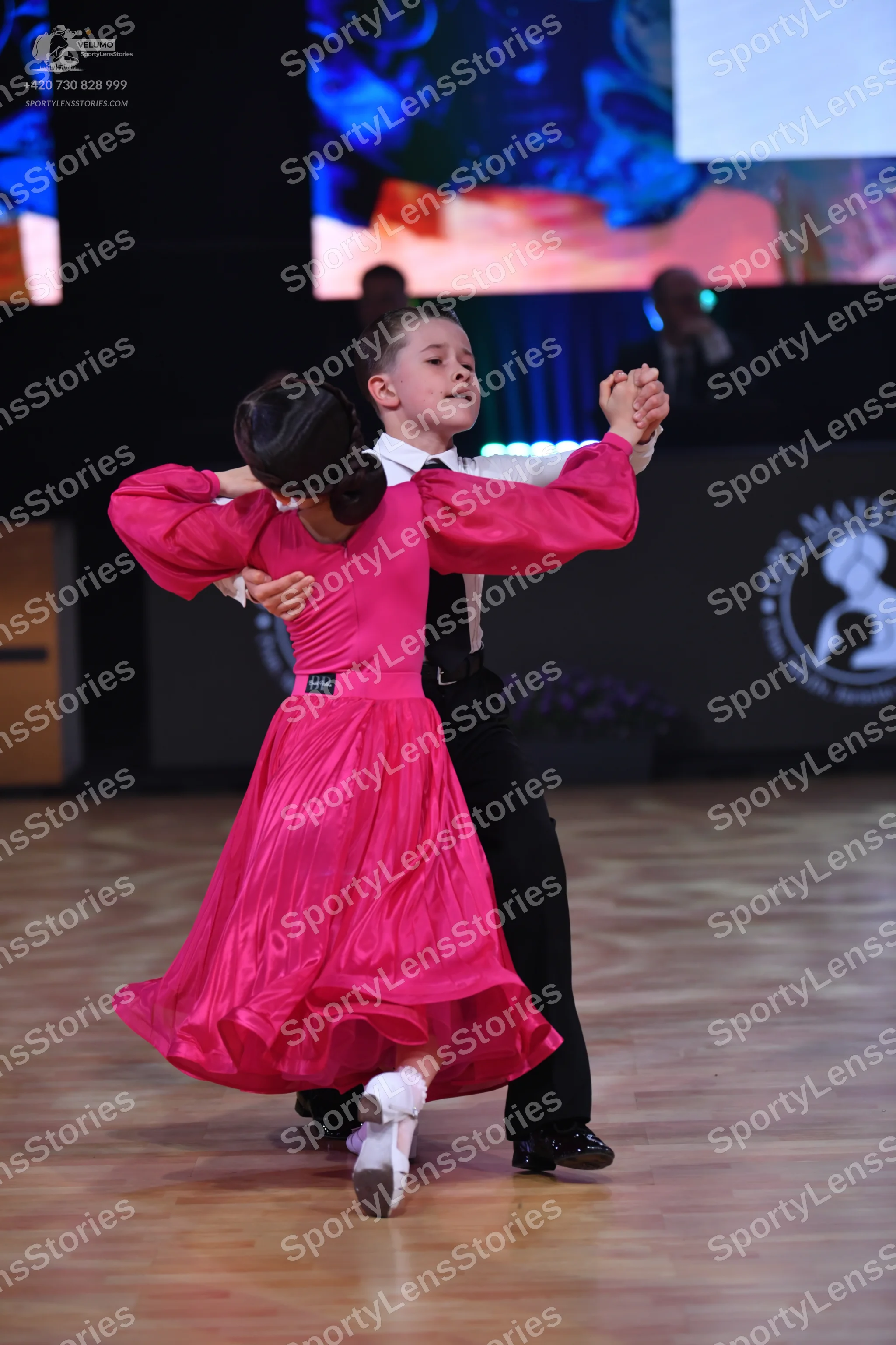 Dancesport competitor: Female dancer: bright pink satin-like ballroom gown with long sleeves