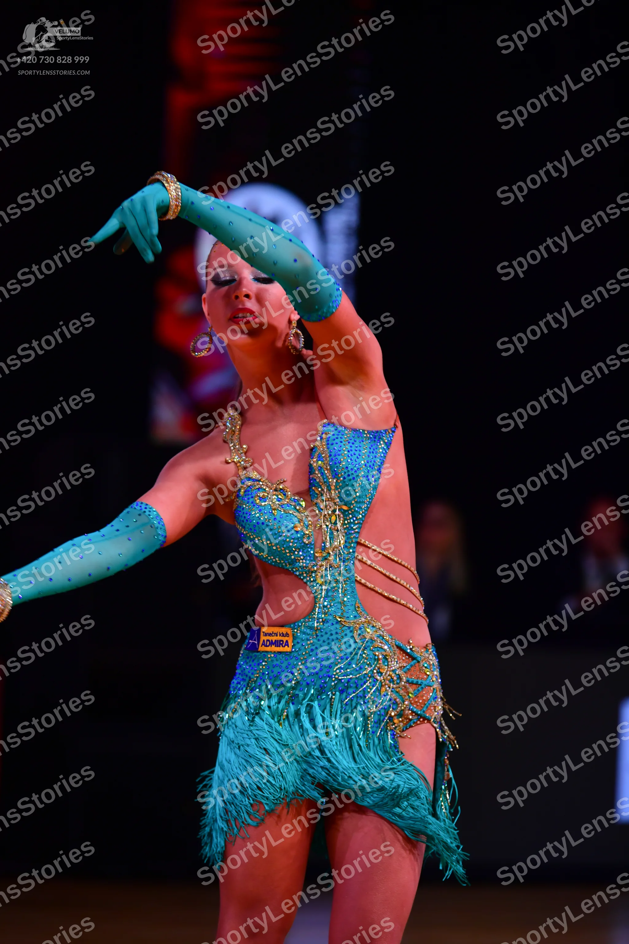 Dancesport competitor: Female dancer: teal Latin dress with gold and silver sequins and beadwork, featu