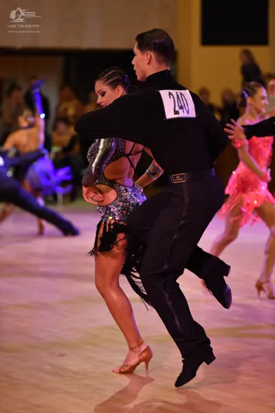 Dancesport competitor #240: Male dancer (foreground): black long-sleeved dance shirt and black trousers