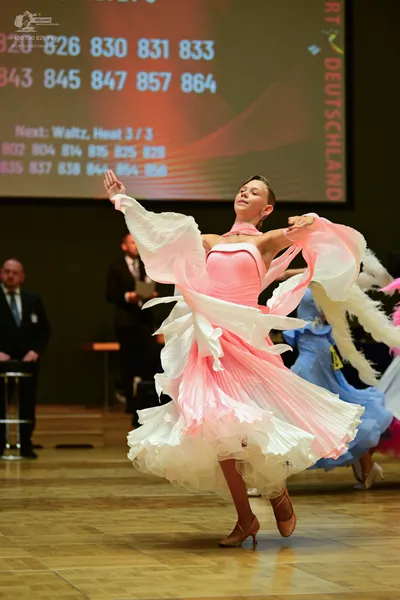 Dancesport competitor: Female:  Pale pink, voluminous ballgown with a fitted bodice and ruffled skirt
