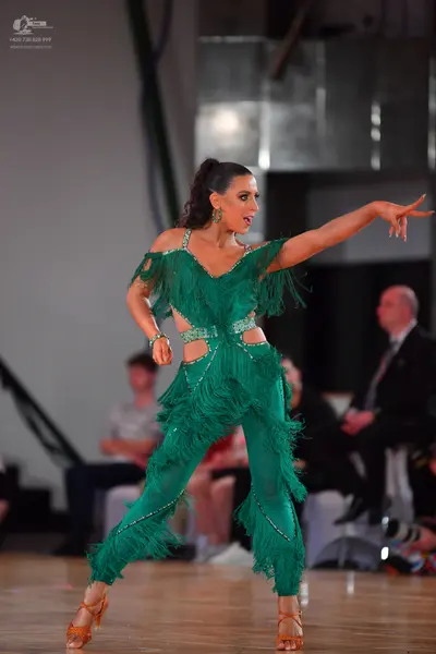 Dancesport competitor: Female dancer: green latin dance costume with fringe, cut-outs, and small embell
