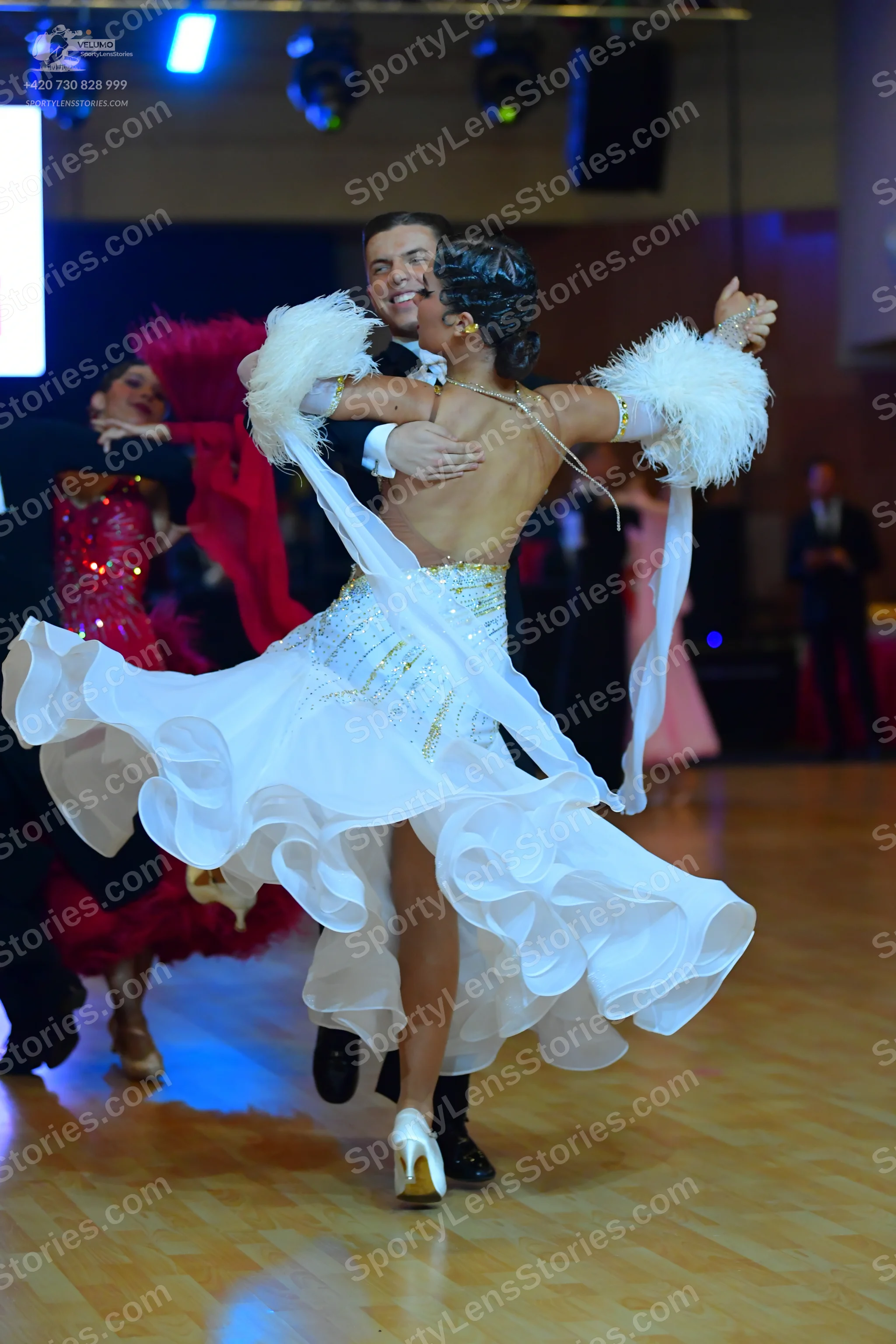 Dancesport competitor: ** White ballroom gown with a dramatic, floor-length skirt
