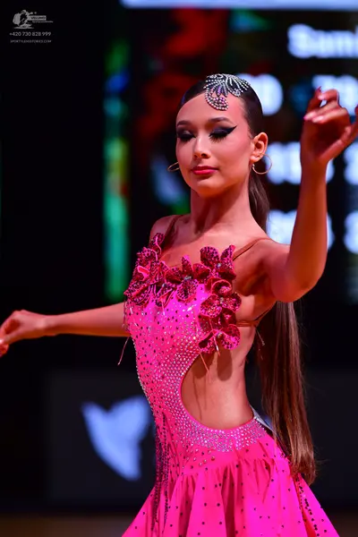 Dancesport competitor: Female dancer: bright pink Latin dress with large dark pink floral appliques, rh