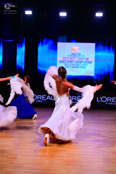 Dancesport competitor: Female dancer 1: white ballroom dress with a decorated bodice and a large, volum