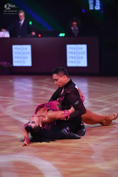Dancesport competitor: Male dancer: black long-sleeved Latin dance top with sequin details and black tr