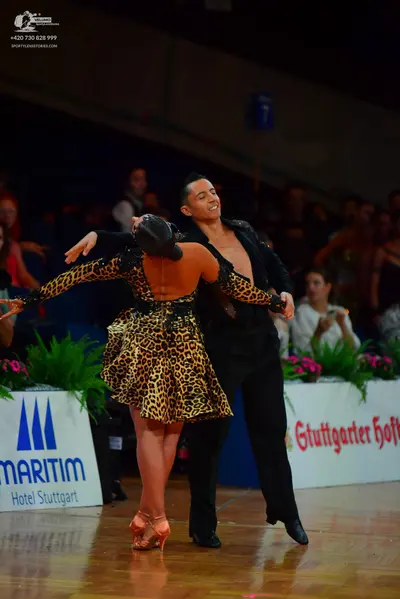 Dancesport competitor: Female dancer: leopard print latin dress with long sleeves and an open back