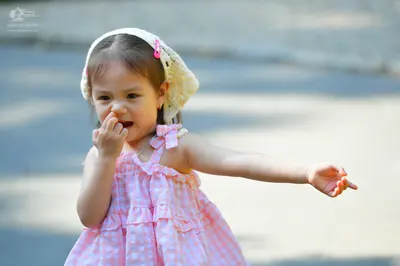 Dancesport competitor: Child: pink sleeveless dress with white polka dots and ruffles, and a white lace