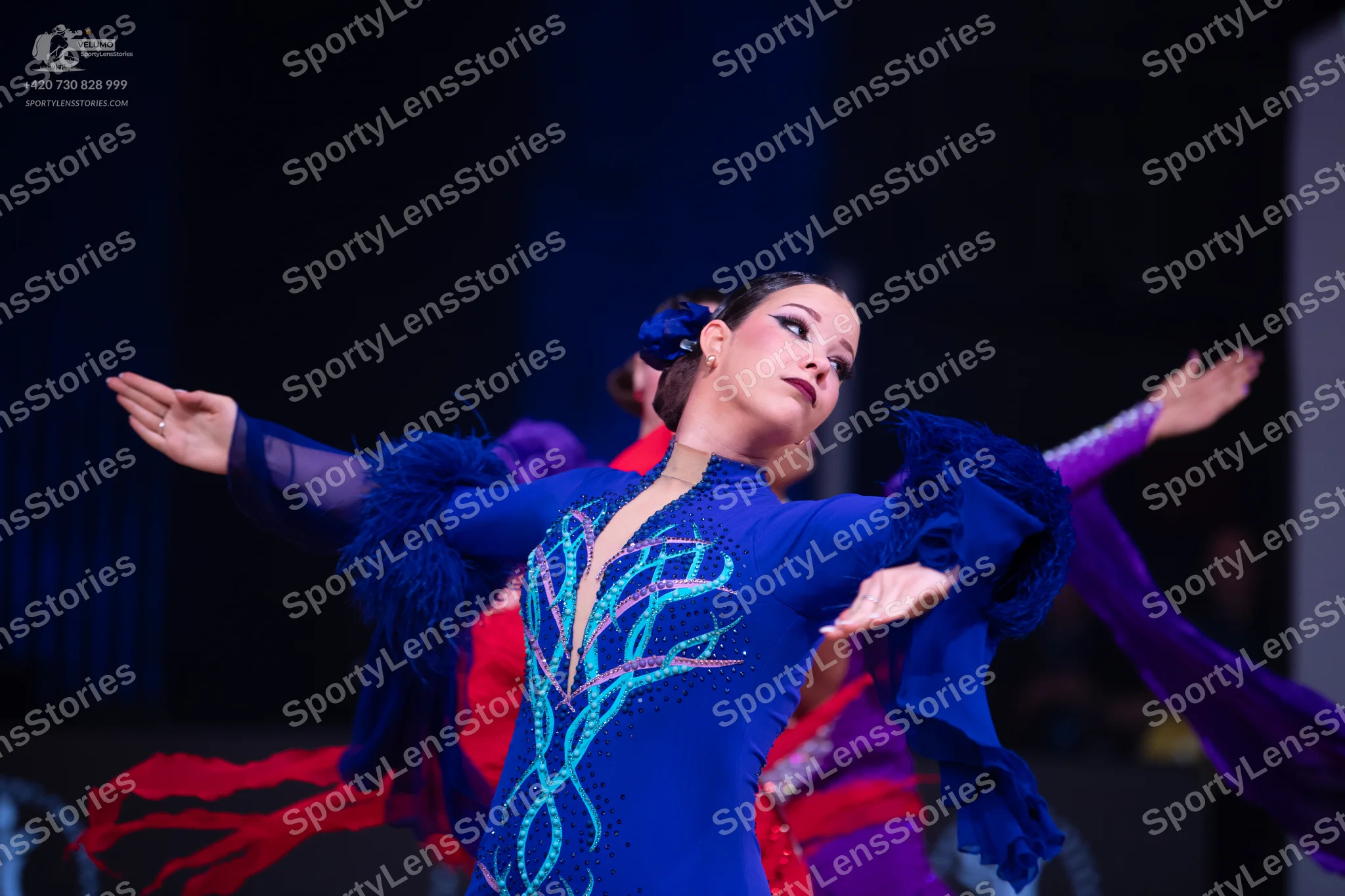 Dancesport competitor: Primary female dancer: royal blue latin dress with turquoise swirling sequin/bea