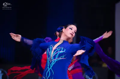 Dancesport competitor: Primary female dancer: royal blue latin dress with turquoise swirling sequin/bea