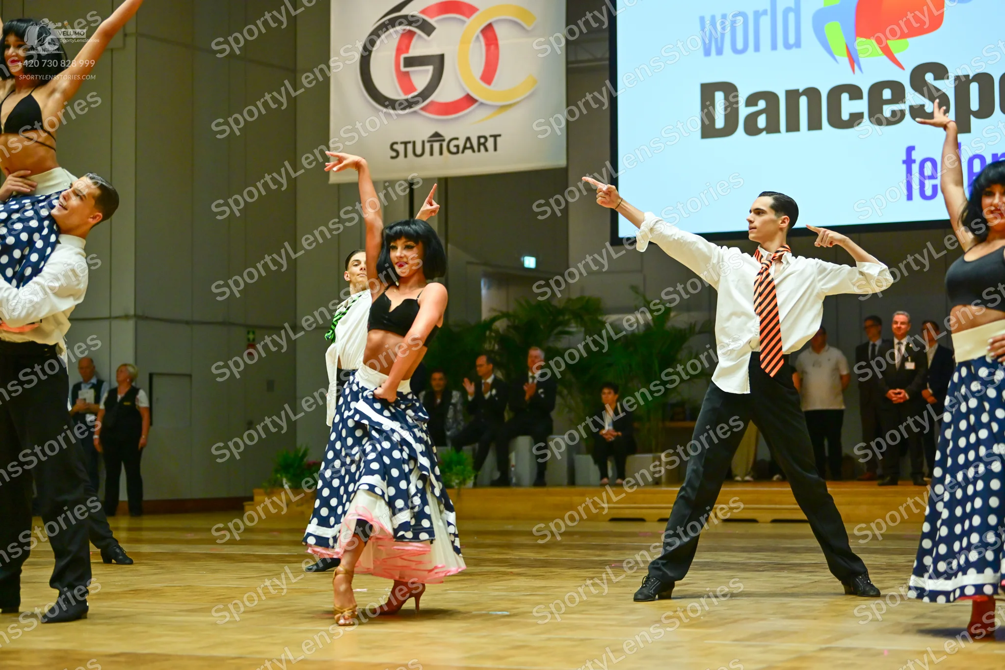 Dancesport competitor: Male dancers: white long-sleeve shirts, black trousers, and black shoes; one mal