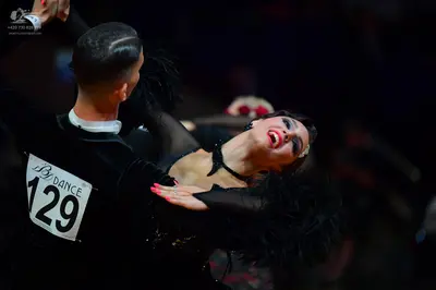 Dancesport competitor #129: Male dancer: black long-sleeved shirt with a white collar