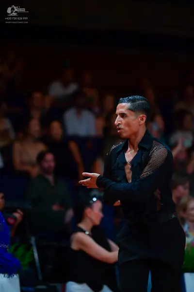 Dancesport competitor: Male dancer: black long-sleeved Latin dance shirt with a sheer mesh panel on the