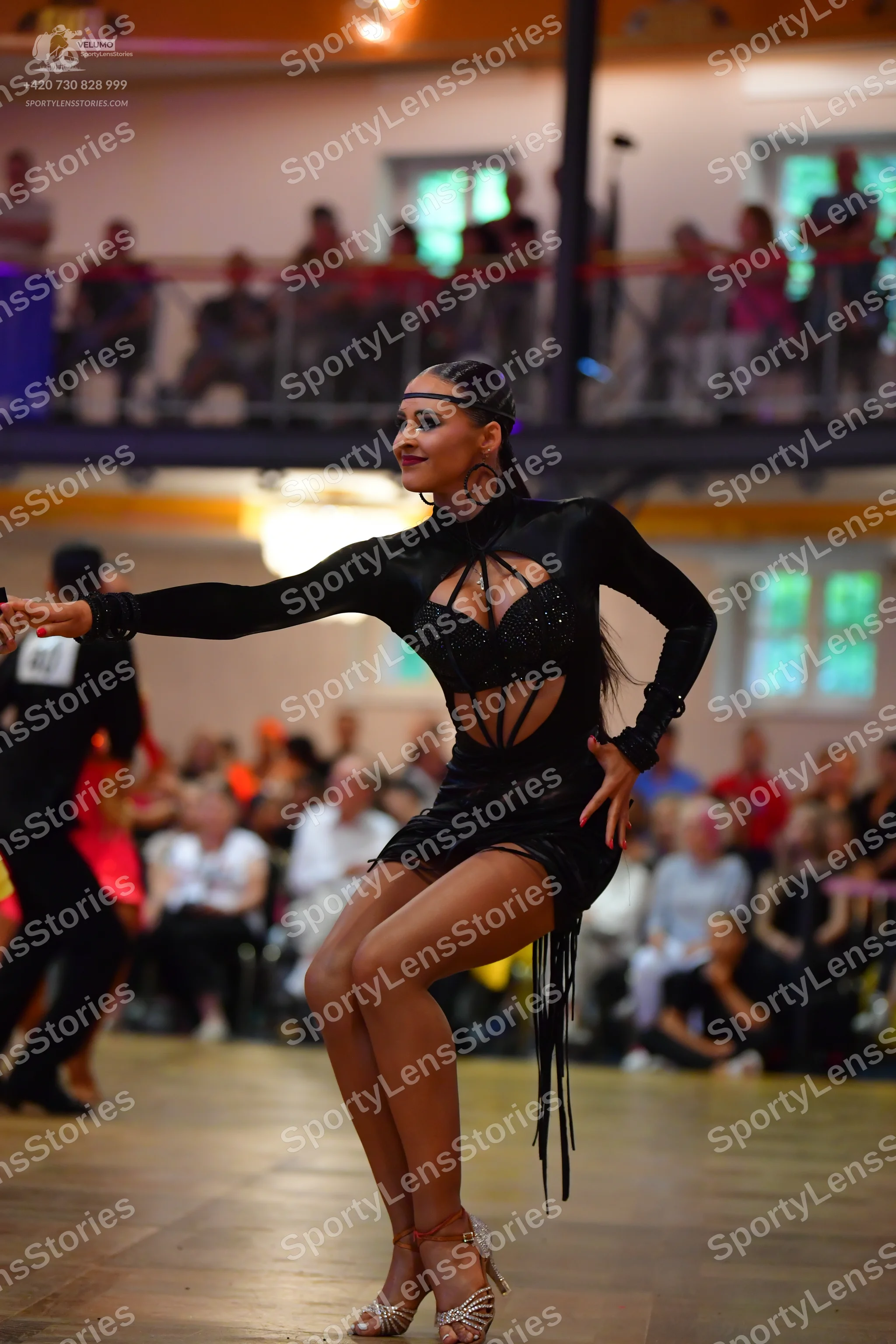 Dancesport competitor: Female dancer: black latin dress with long sleeves, cutouts on the bodice, and l