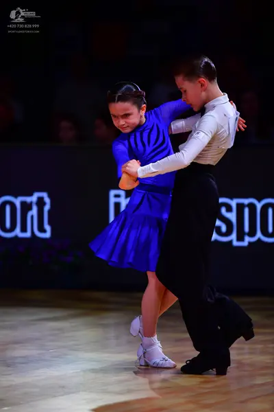 Dancesport competitor: Female dancer: royal blue short-sleeved dress made of smooth fabric and white da