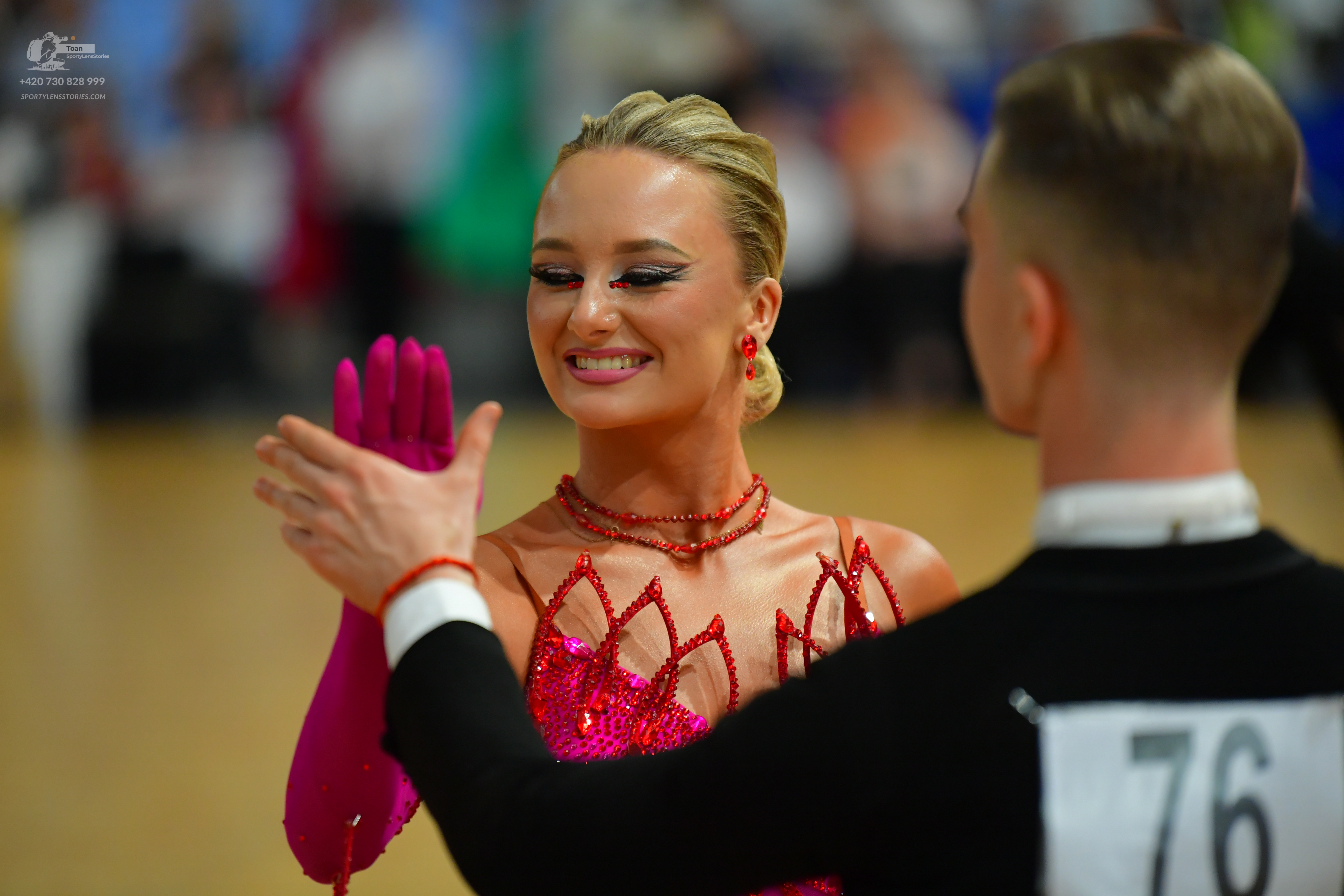 Dancesport competitor #76: Here's a breakdown of the dancers' costumes in the photo, formatted as requested