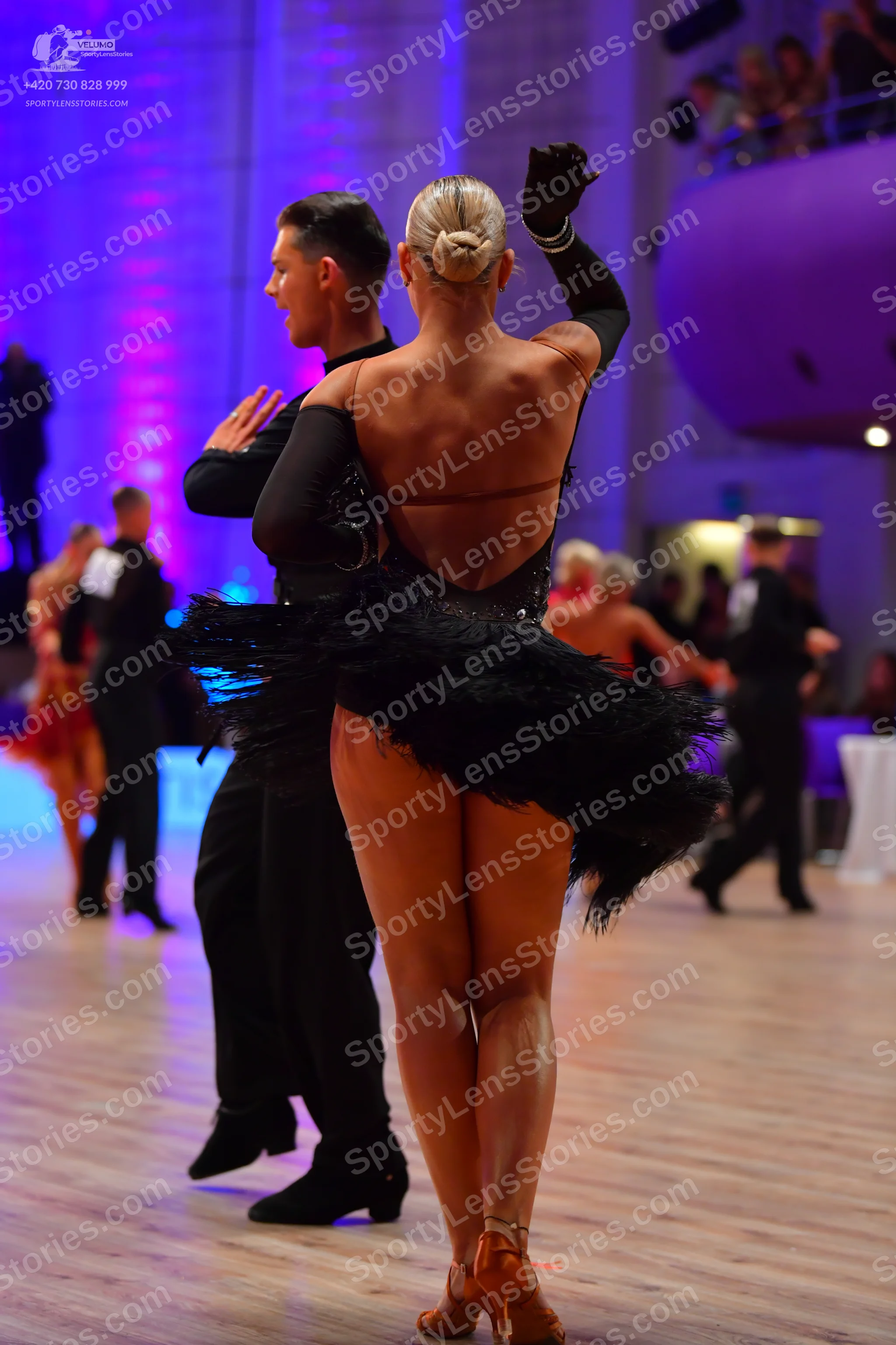 Dancesport competitor: Female dancer: black latin dress with an open back and a skirt featuring black f