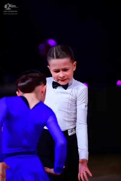 Dancesport competitor: Male dancer: white long-sleeved shirt with a black bow tie and black trousers